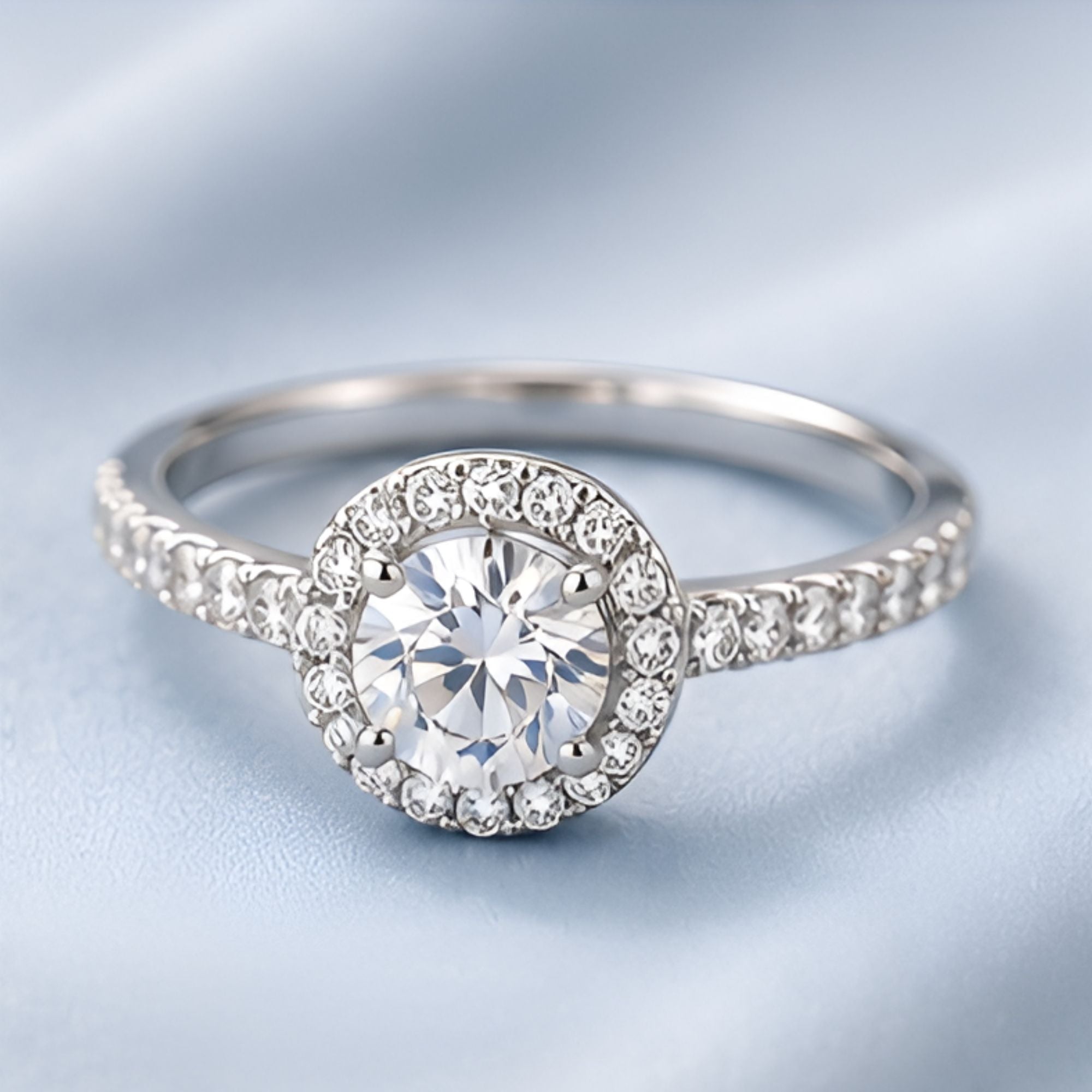 Bague argentée à pierre ronde et halo pavé
