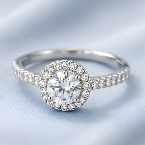 Bague argentée à pierre ronde et halo pavé