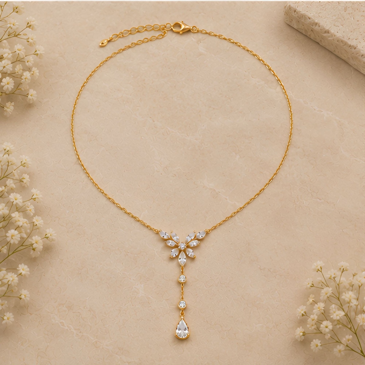Collier doré à pendentif floral avec goutte allongée